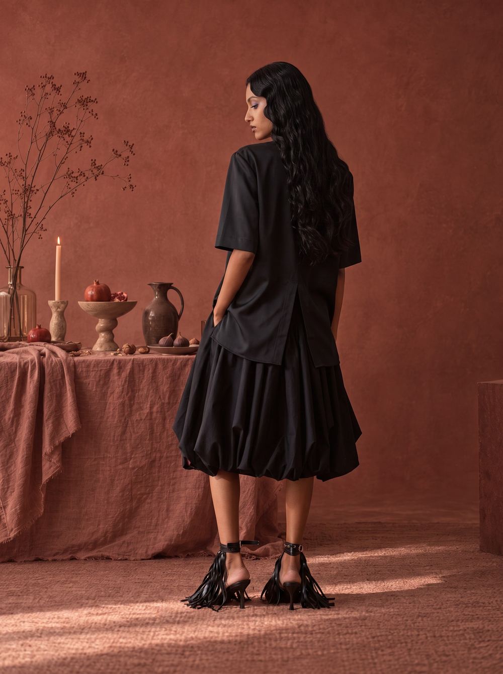 Rear view of the black tee and bubble skirt with tasselled heels.