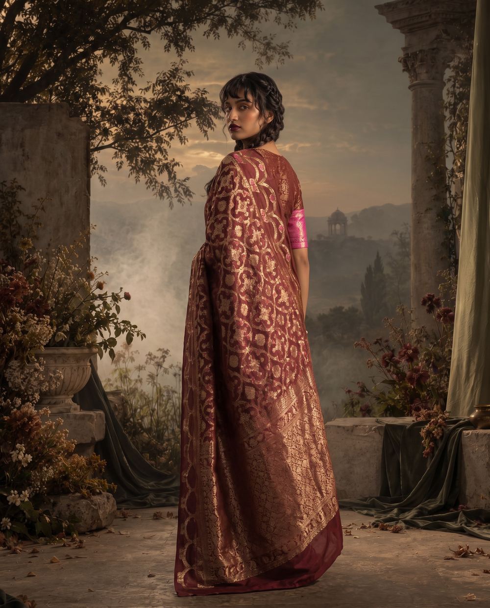Full-length rear view of a maroon saree with its gold border falling open.