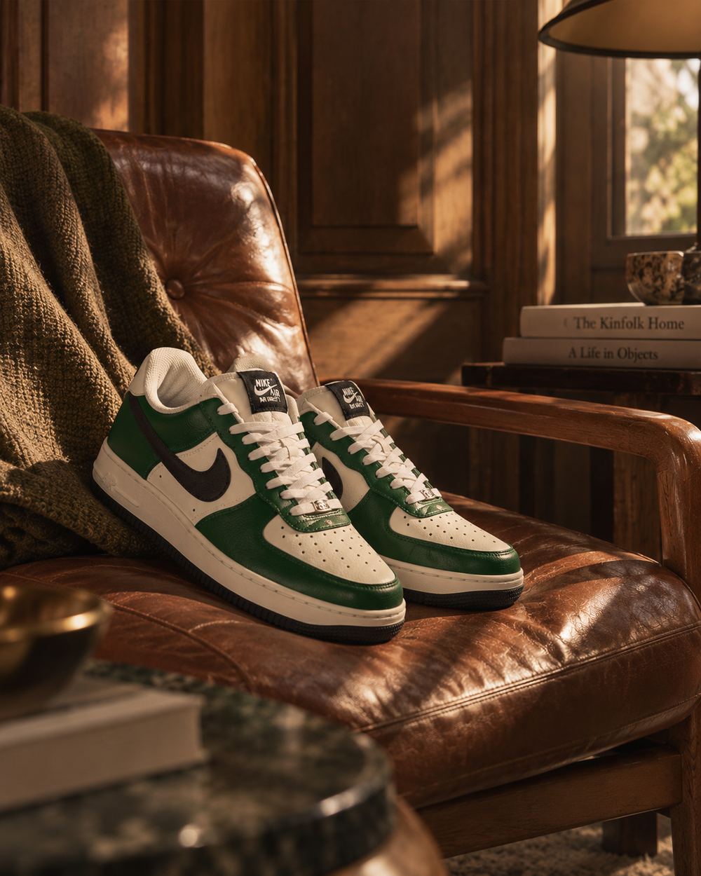 A pair of green and cream sneakers standing on a worn leather armchair beside a striped wool blanket.