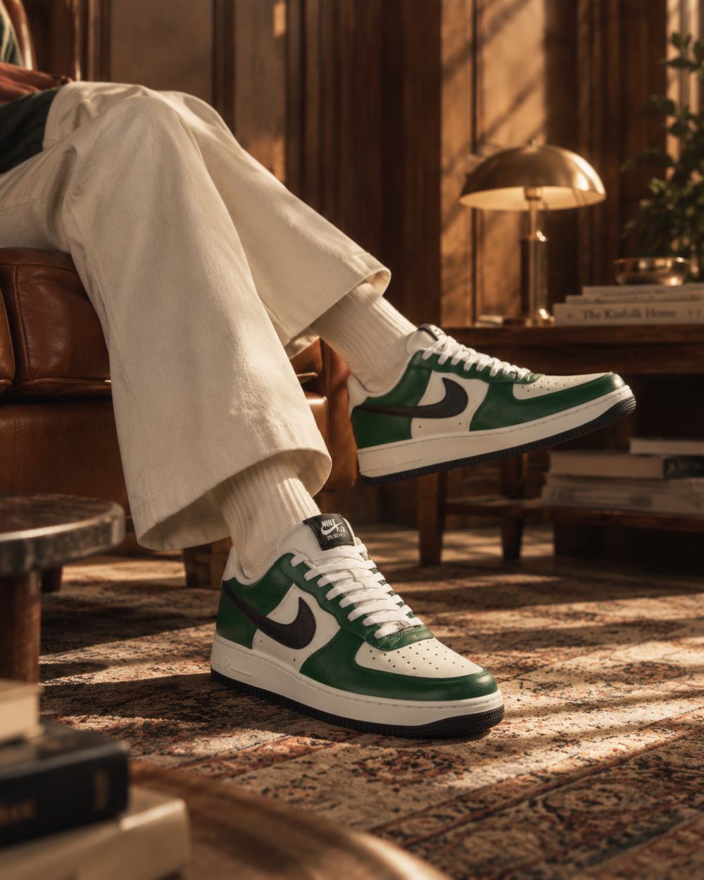 Wide frame of the green sneakers worn on a low seat, sunlight falling across the carpet and books.